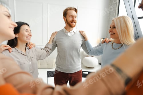 Preview: Group of diverse positive multinational women and men standing in cycle holding hands having meeting