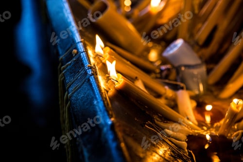 Preview: Closeup shot of many burning candles in a church