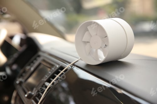 Preview: Portable fan on dashboard in car. Summer heat