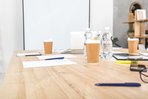 Preview: empty business workplace with disposable cups, digital devices and papers in office