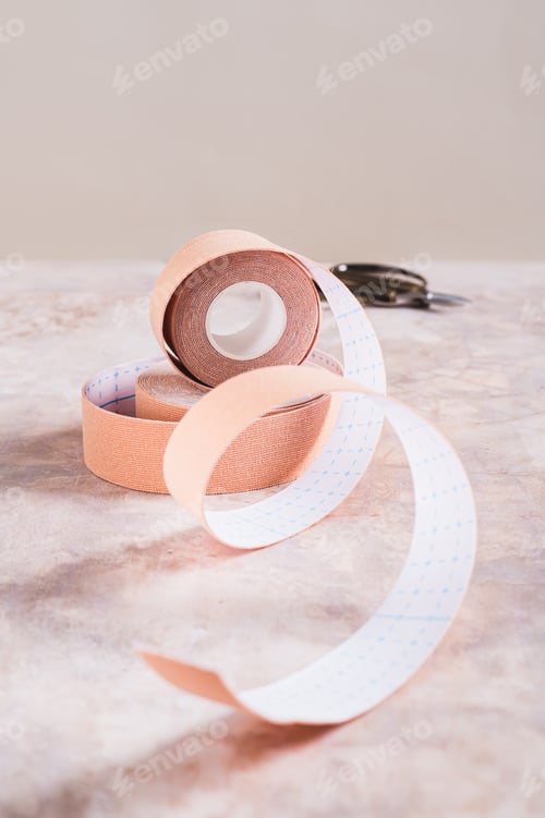 Preview: Modern trend against aging and wrinkles kinesio tape in a roll on the table vertical view