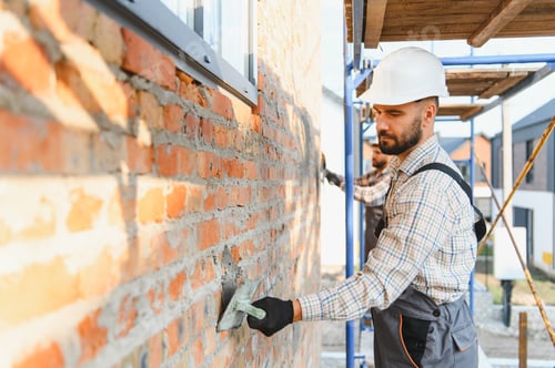 Preview: Construction worker laying brick wall with trowel