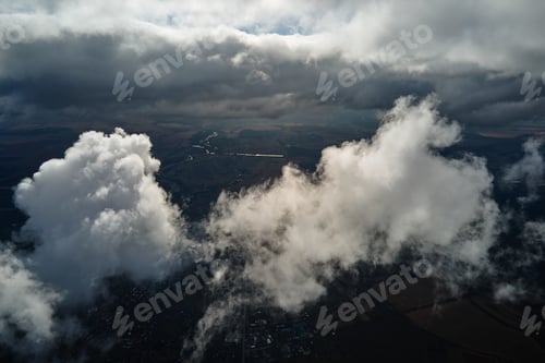Preview: Aerial view from airplane window at high altitude of earth covered with white puffy cumulus clouds
