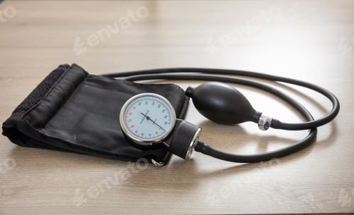Preview: Medical sphygmomanometer on wooden desk, closeup view.
