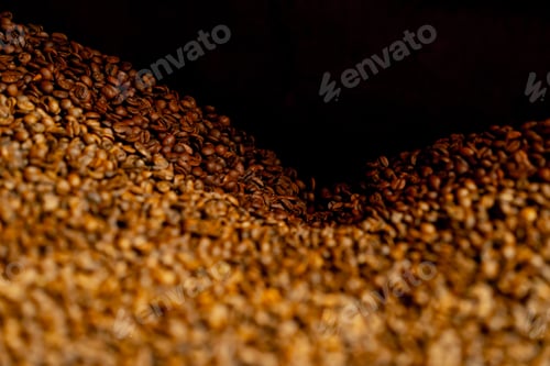Preview: Close up of freshly roasted coffee in roasting factory in a coffee roasting machine