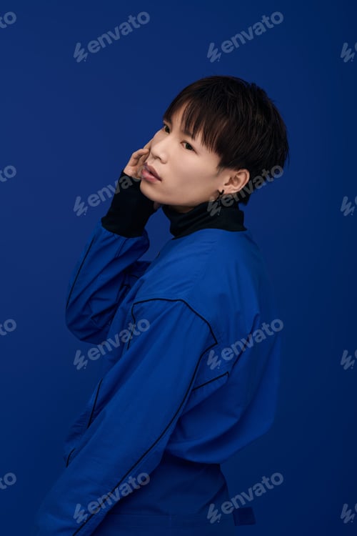 Preview: Capturing the charm of a young handsome asian man in a captivating blue backdrop