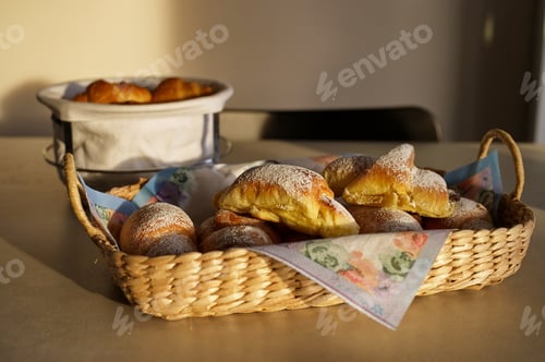 Preview: Group of delicious buns in wicker basket on the table lit with setting sun