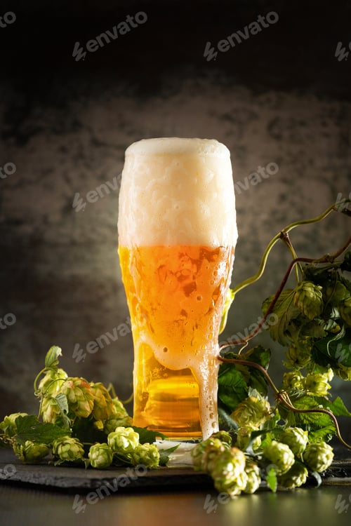 Preview: Glass of dark beer with hops around on a dark background