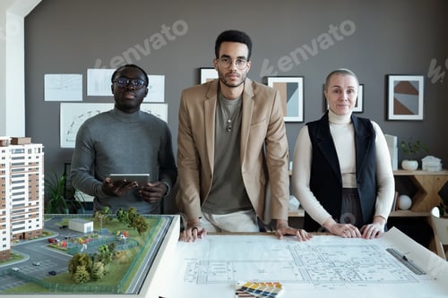 Preview: Three contemporary professionals of various ethnicities standing by table