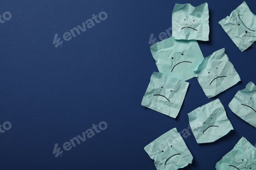 Preview: Papers with sad emoji on dark blue background, space for text