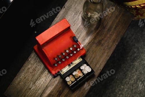 Preview: High angle shot of a small vintage cashier machine on a wooden surface