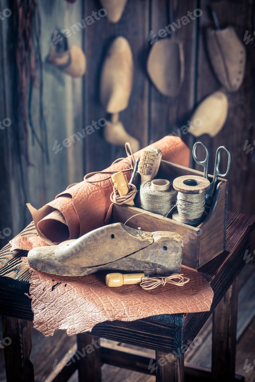 Preview: Closeup of shoemaker workshop with tools, leather and shoes
