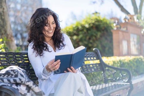 Preview: Woman reading book on park bench enjoying outdoors