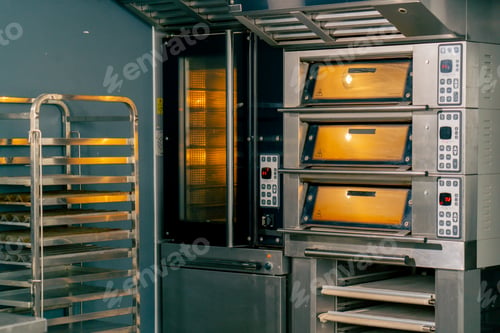 Preview: turned on preheated hot oven baking large quantities of baked goods in a professional bakery kitchen