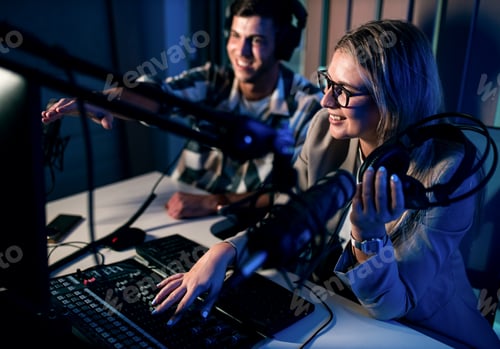 Preview: Young woman and man editing audio podcast in their studio.