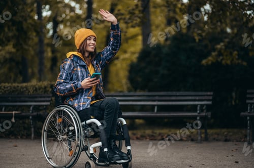 Preview: Woman with disability using a smartphone while out in the city park