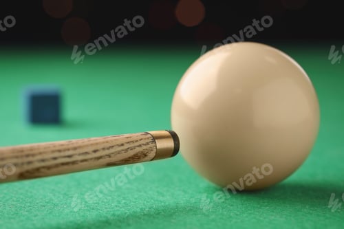 Preview: Classic plain billiard ball and cue on green table, closeup