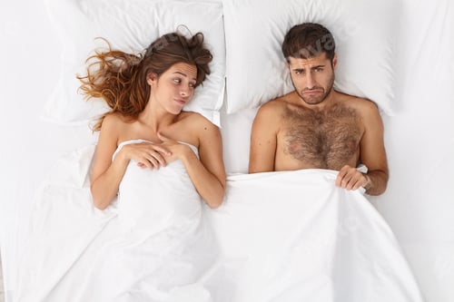 Preview: Man impotent has erectile dysfunction, looks under blanket with frustrated expression, unsatisfied w