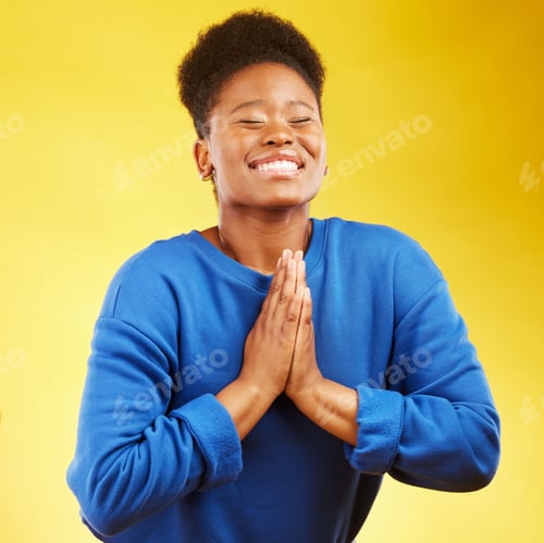Preview: Thank you, hands and black woman praying in studio happy, relief and grateful on yellow background.