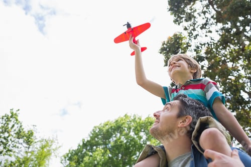 Preview: Low Angle View Of A Boy With Toy Aeroplane Sitting On Father'S Shoulders At The Park