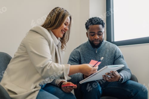 Preview: Business people working together using sticky notes and notepad in office meeting