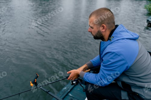 Preview: Fisherman with fishing rod or spinning rod and professional tools sitting on the river bank