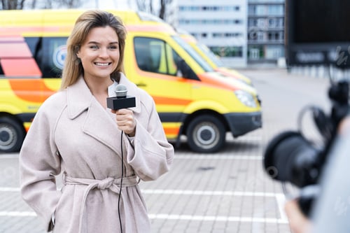 Preview: Smiling news reporter speaking into a microphone