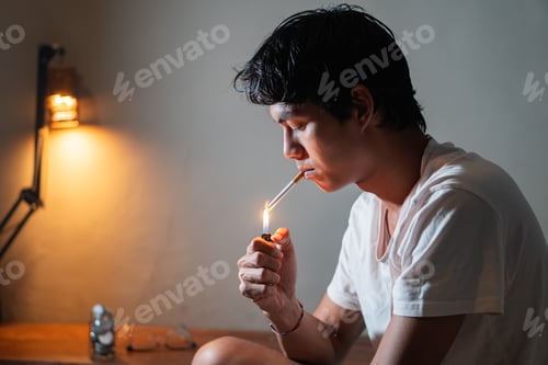 Preview: Man Lighting Cigarette Indoors at Night