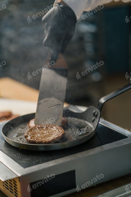 Preview: A professional kitchen chef is frying cutlets for a burger