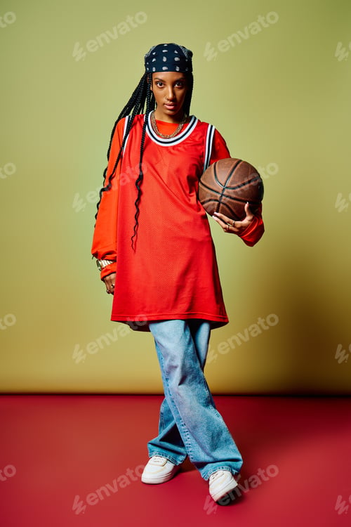 Preview: A stylish young woman holds a basketball, standing tall against a vibrant backdrop.