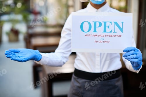Preview: Unrecognizable waitress holding open sign for takeaway only due to coronavirus epidemic.