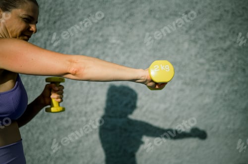 Preview: Sportswoman doing exercises with dumbbells