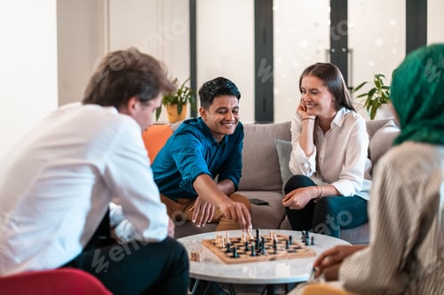 Preview: Multiethnic group of business people playing chess while having a break in relaxation area at