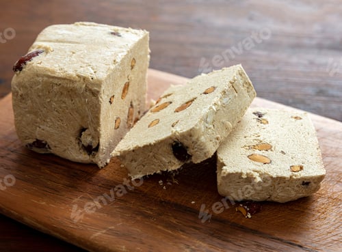 Preview: Halva almond nuts slices on wooden table background
