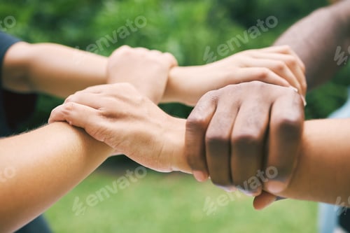 Preview: Hands holding wrists outside in nature. A diverse group of people holding wrist as a concept of loy