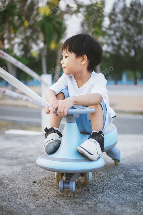 Preview: Asian little boy playing swing car in the garden