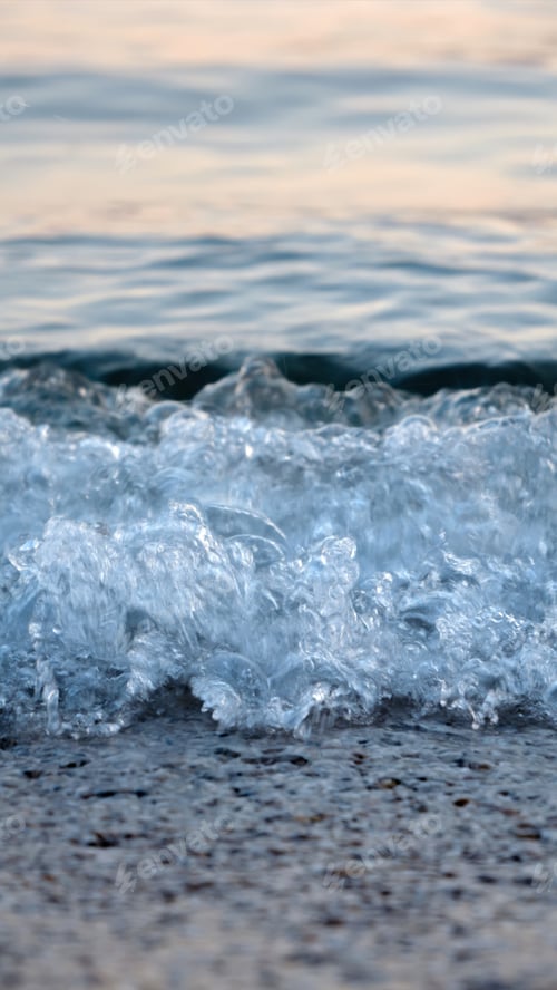 Preview: Macro shot of calm blue sea waves rolling and breaking on a sea beach on sunset