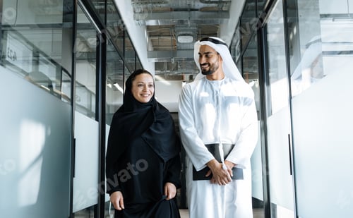 Preview: handsome man and woman with traditional clothes working in an office of Dubai