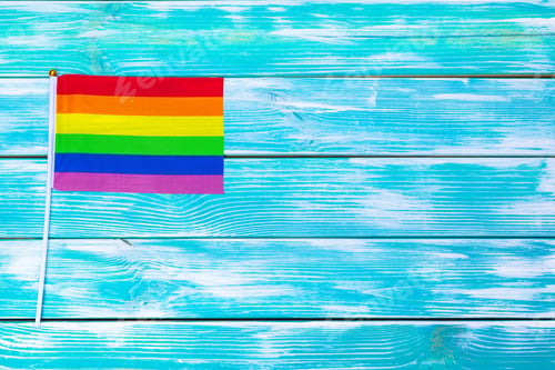 Preview: Gay pride flag on wooden table. Close up