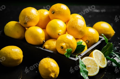 Preview: Fresh lemons. On black table.