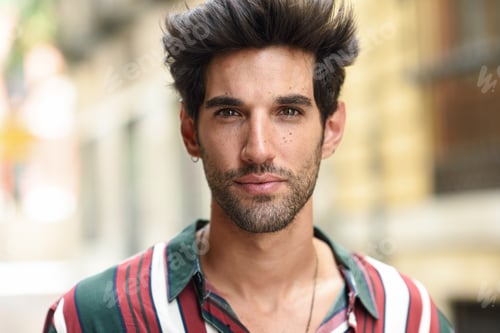Preview: Attractive young man with dark hair and modern hairstyle wearing casual clothes outdoors