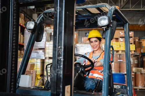 Preview: Portrait of a woman working with a forklift in a warehouse with her looking at the camera.
