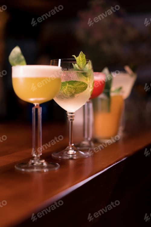 Preview: Close up of cocktails of different colors in different glasses standing on the bar in club bar