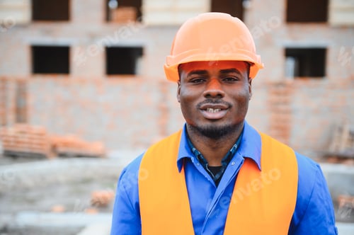 Preview: An African American construction worker, in work clothes and a hard hat, is building a brick house