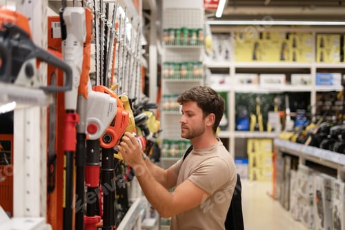 Preview: Male choosing trimmer from gardening tools