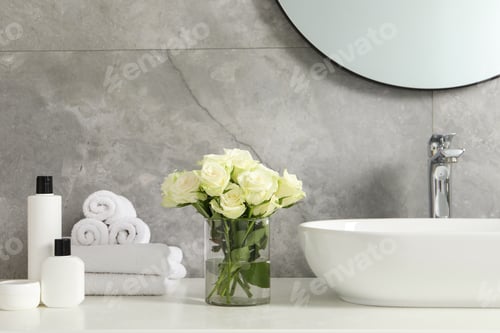 Preview: Beautiful roses and bath accessories near sink in bathroom