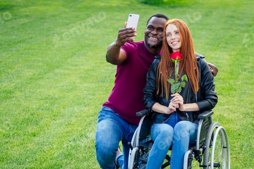 Preview: afro american man sitting on wheelchair ,his redhaired ginger girlfriend rolling stroller