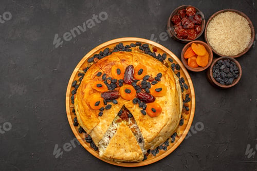 Preview: top view shakh plov delicious rice meal cooked inside round dough with raisins on a grey background