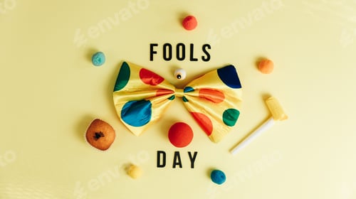 Preview: Clown tie with treats and various accessories and the phrase Fools' Day on a yellow background.