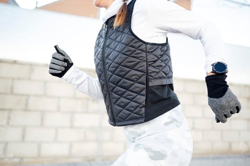 Preview: Sportswoman running around industrial zone in winter while sun rising.